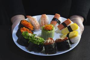 Rollo de sushi maki japonés que sirve en un restaurante oriental, el chef está preparando el menú de cocina tradicional de Japón, varios diferentes conceptos variados de comida saludable mixta de lujo foto