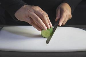 el chef está preparando pepino fresco para hacer el menú de cocina tradicional de Japón, rollo de sushi maki japonés que se sirve en un restaurante oriental, varios conceptos variados de comida saludable mezclada de lujo foto