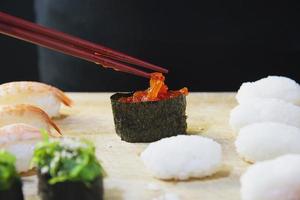 Rollo de sushi maki japonés que sirve en un restaurante oriental, el chef está preparando el menú de cocina tradicional de Japón, varios diferentes conceptos variados de comida saludable mixta de lujo foto