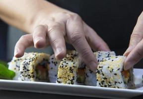 Rollo de sushi japonés que sirve en un restaurante oriental, el chef está preparando el menú de cocina tradicional de Japón, varios diferentes conceptos variados de comida saludable mixta de lujo foto