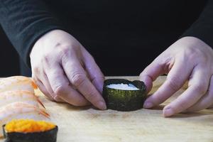 japanese maki sushi roll serving in oriental restaurant, chef is preparing japan tradition cookery menu, various different assorted luxury mixed healthy eating set concept photo