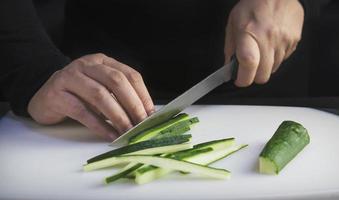 chef is preparing fresh cucumber for making japan tradition cookery menu, japanese maki sushi roll serving in oriental restaurant, various different assorted luxury mixed healthy eating set concept photo