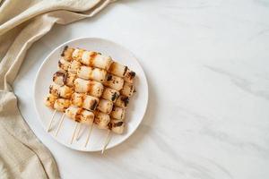 pastel de pasta de pescado en forma de tubo a la parrilla skewe o pincho de calamar en tubo foto