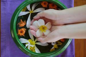 mano femenina y flor en agua foto