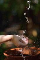 salpicando agua dulce en manos de mujer foto