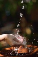 salpicando agua dulce en manos de mujer foto