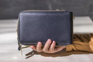 Close up woman hand holding a woman's wallet on abstract white background photo