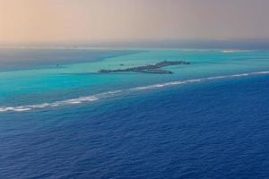 Maldives paradise sunset. Tropical aerial landscape, seascape island shore, boats water villas with amazing sea and lagoon beach, tropical nature. Exotic tourism destination banner, summer vacation photo