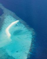 imagen aérea de la laguna oceánica tropical azul turquesa, playa de arena blanca, arrecife de coral de banco de arena aguas poco profundas con un barco. perfección de la naturaleza en el mar de maldivas. experiencia de vida de lujo, paisaje tranquilo foto