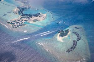 Beautiful drone aerial view of Maldives. High aerial landscape, boats passing by, coral reef with ocean lagoon