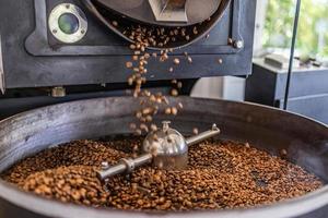 máquina tostadora de café en el proceso de tostado de café. mezclando granos de café. foto