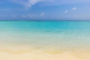 Closeup of sand on beach and blue summer sky. Panoramic beach landscape. Empty tropical beach and seascape. Bright sunny sky, soft sand, calmness, tranquil relaxing sunlight, summer mood photo