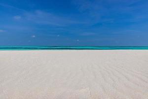 primer plano de la arena en la playa y el cielo azul de verano. paisaje panorámico de la playa. playa tropical vacía y paisaje marino. cielo soleado brillante, arena suave, calma, luz solar tranquila y relajante, estado de ánimo de verano foto