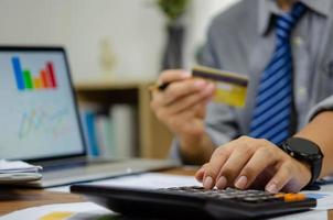 employee of a company paying a charge with a credit card while conducting internet shopping. Concept of tax and accounting in business. photo