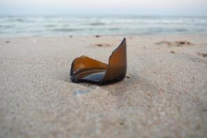 waste of broken bottle on sea sand background photo