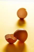 Egg shells on yellow surface with more shells in the background. View in the foreground. Food for a healthy life. Vertical image. photo