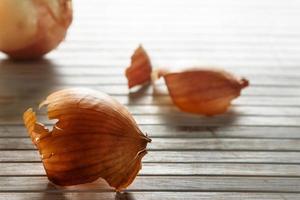 Onion skin in the foreground against the light with more onion skins in the background on wooden boards. Horizontal image. photo