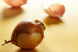 Onion with backlight with onion skins at the bottom on yellow surface. Healthy life concept. Horizontal image. photo