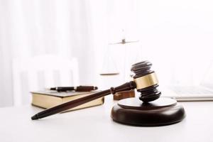 Justice and law concept.Male judge in a courtroom with the gavel, working with, computer and docking keyboard, eyeglasses, on table in morning light photo