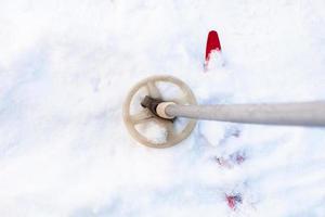 esquí cubierto de nieve y bastón de esquí antiguo foto