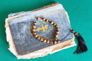 cuentas de preocupación en el viejo libro de salmos en la mesa verde foto