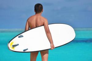 hombre con tabla de surf en la playa foto