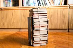 stack of used books tied with packthread on floor photo