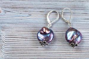 earrings from iridescent baroque pearls on gray photo