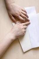 top view of blind woman reads note in braille