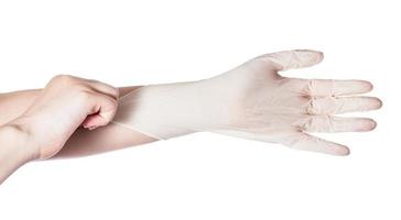 top view of hand pulls latex glove on another hand photo