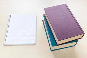 dos libros gruesos y un cuaderno espiral en blanco foto