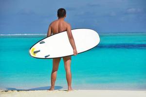 Man with surf board on beach photo