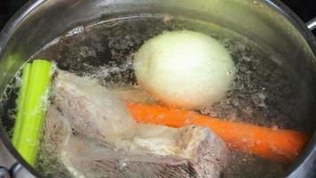 Caldo de carne hirviendo en una cacerola de estofado cerrar cerrar foto