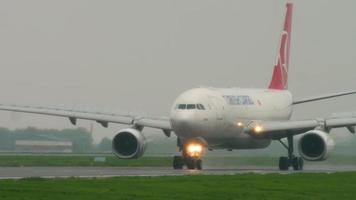 almaty, kazachstan 4 mei 2019 - turkse vracht-airbus a330 tc jdr remmen na landing op de startbaan bij regenachtig weer. luchthaven van almaty, kazachstan video