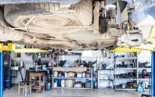 bottom view of old car with broken shock absorber photo