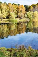 colorful shore of pond in city park in autumn photo