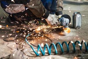 mechanic cuts new pipe for corrugation muffler photo