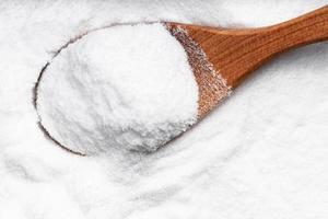 top view of wood spoon with dextrose sugar closeup photo