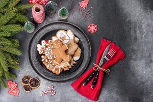 pan de jengibre, adornos de árboles de Navidad, cítricos secos sobre un fondo de hormigón gris foto