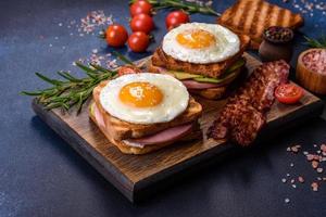 Fresh, delicious sandwiches with fried egg, ham, butter, avocado and sesame seeds photo