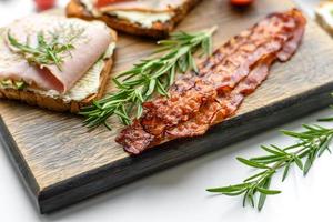 Fresh, delicious ham, butter, avocado and sesame seeds sandwiches on a wooden cutting board photo