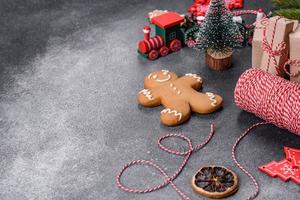 pan de jengibre, adornos de árboles de Navidad, cítricos secos sobre un fondo de hormigón gris foto
