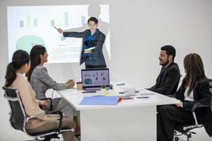 los colegas masculinos y femeninos del equipo de negocios asiático que hablan en el trabajo comparten ideas con el gráfico a bordo, los colegas jóvenes felices de presentación trabajan juntos a bordo. foto