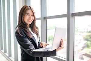 retrato de una hermosa mujer de negocios asiática que trabaja en la oficina, usando una computadora. concepto de negocio foto