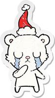 crying polar bear distressed sticker cartoon of a wearing santa hat vector