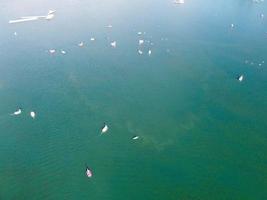 bellas imágenes de la cámara de drones aéreos del lago y parque willen que se encuentra en milton keynes, inglaterra. la gente está disfrutando en el lago en un caluroso día soleado de verano foto