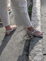 Female legs in sandals. Summer street fashion. photo