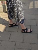 Female legs in sandals. Summer street fashion. photo