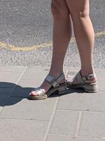 Female legs in sandals. Summer street fashion. photo