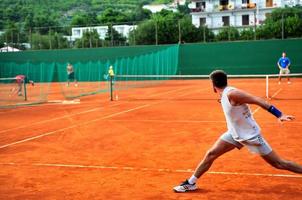 Man plays tennis outdoors photo